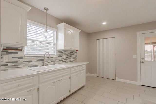 1050 Assisi Ln, Jacksonville, FL 32233 - kitchen with a sink, tasteful backsplash, white cabinets, baseboards, and light countertops