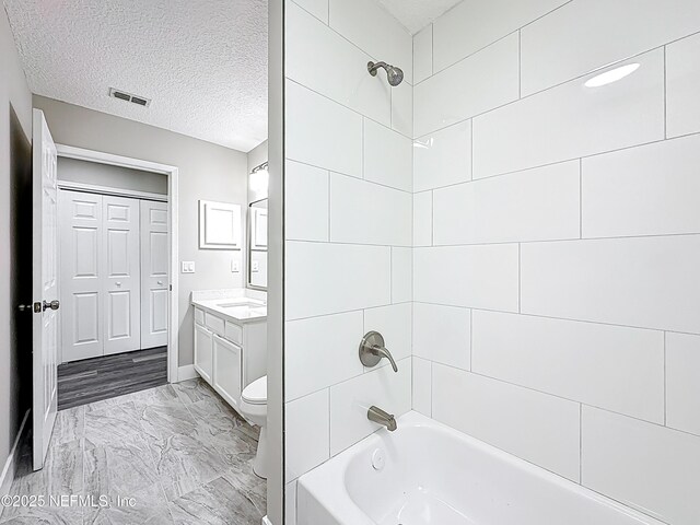 12406 Eagles Claw Ln, Jacksonville, FL 32225 - full bath featuring vanity, bathing tub / shower combination, marble finish flooring, toilet, and a textured ceiling