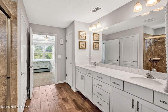 328 Falcon Quest Ln, Saint Augustine, FL 32095 - ensuite bathroom featuring double vanity, wood tiled floors, a stall shower, a ceiling fan, and baseboards