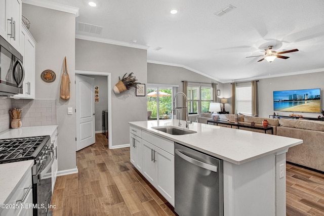 328 Falcon Quest Ln, Saint Augustine, FL 32095 - kitchen featuring stainless steel appliances, a sink, open floor plan, crown molding, and wood finished floors