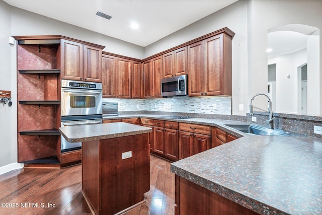 3746 Cardinal Oaks Cir, Orange Park, FL 32065 - kitchen featuring a sink, appliances with stainless steel finishes, open shelves, dark countertops, and arched walkways