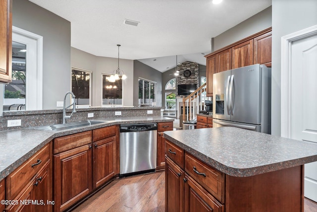 3746 Cardinal Oaks Cir, Orange Park, FL 32065 - kitchen with appliances with stainless steel finishes, dark countertops, a sink, lofted ceiling, and wood finished floors