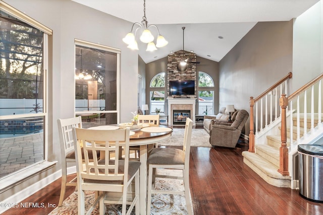 3746 Cardinal Oaks Cir, Orange Park, FL 32065 - dining space with dark wood-type flooring, lofted ceiling, a chandelier, a glass covered fireplace, and stairs