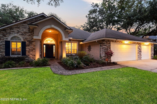 3746 Cardinal Oaks Cir, Orange Park, FL 32065 - view of front facade with concrete driveway, stone siding, an attached garage, stucco siding, and a front yard