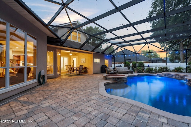 3746 Cardinal Oaks Cir, Orange Park, FL 32065 - pool at dusk with a patio area, a pool with connected hot tub, outdoor dining area, and a lanai