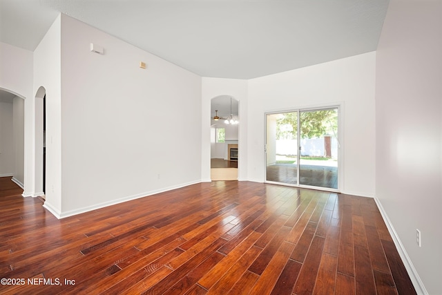 337 Bell Branch Ln, Saint Johns, FL 32259 - empty room featuring arched walkways, dark wood finished floors, and baseboards
