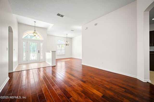 337 Bell Branch Ln, Saint Johns, FL 32259 - foyer entrance featuring arched walkways, dark wood-style floors, baseboards, and a chandelier
