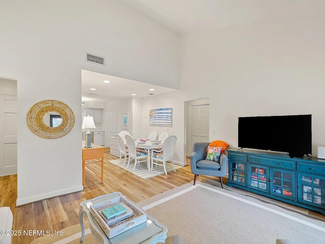 2700 Mizell Ave Unit 402B, Fernandina Beach, FL 32034 - living room featuring light wood-type flooring, a high ceiling, baseboards, and recessed lighting