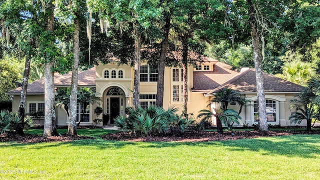 2708 Shade Tree Dr, Fleming Island, FL 32003 - mediterranean / spanish home with stucco siding, a front lawn, and roof with shingles