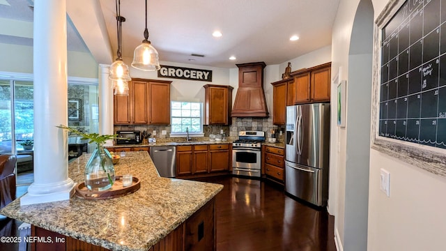 2708 Shade Tree Dr, Fleming Island, FL 32003 - kitchen with appliances with stainless steel finishes, premium range hood, brown cabinetry, backsplash, and recessed lighting