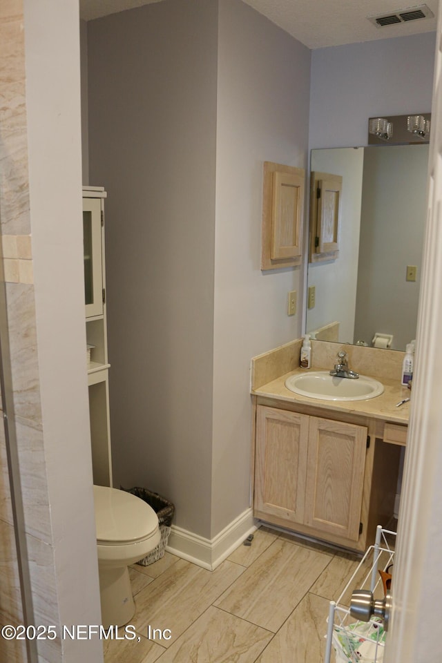 7589 Ginger Tea Trl W, Jacksonville, FL 32244 - bathroom with toilet, vanity, wood finished floors, and baseboards