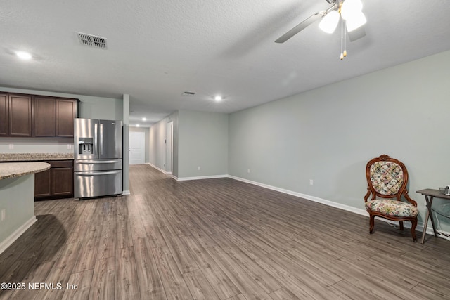 8552 Lake George Cir W, Macclenny, FL 32063 - kitchen with stainless steel fridge with ice dispenser, dark brown cabinets, wood finished floors, a ceiling fan, and baseboards