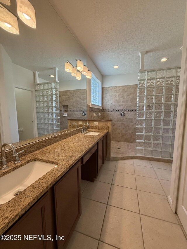 9205 Camshire Dr, Jacksonville, FL 32244 - full bathroom featuring a walk in shower, tile walls, double vanity, a textured ceiling, and tile patterned floors