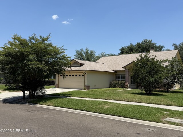 9205 Camshire Dr, Jacksonville, FL 32244 - view of front of house featuring an attached garage, concrete driveway, a front lawn, and a chimney