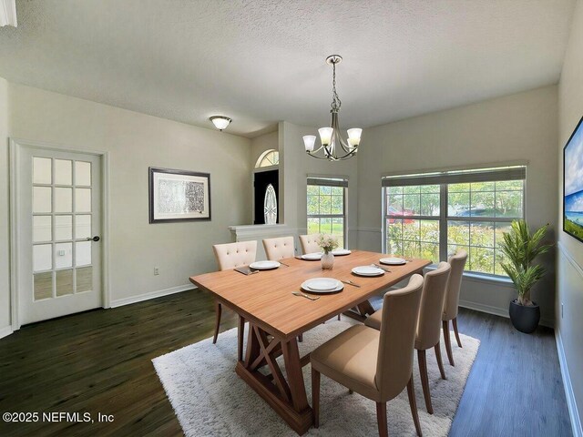 9205 Camshire Dr, Jacksonville, FL 32244 - dining area with a chandelier, baseboards, dark wood finished floors, and a textured ceiling