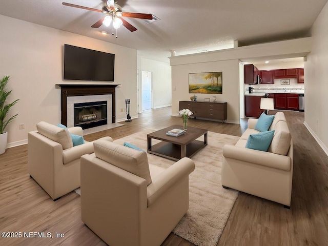 9205 Camshire Dr, Jacksonville, FL 32244 - living area with ceiling fan, light wood-type flooring, a high end fireplace, and baseboards