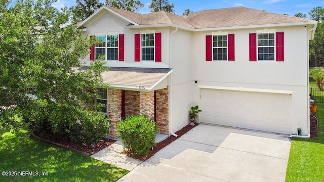 65074 Mossy Creek Ln, Yulee, FL 32097 - view of front of property with roof with shingles, a garage, driveway, stone siding, and stucco siding