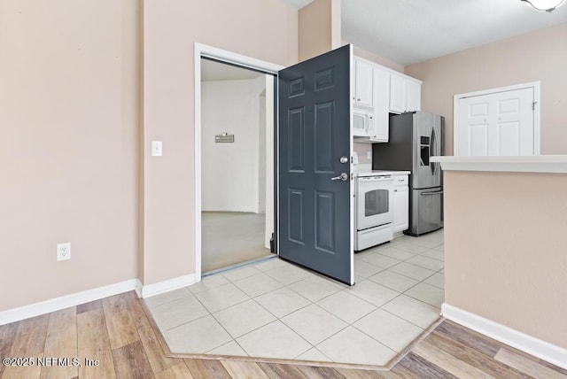 11251 Campfield Dr Unit 4107, Jacksonville, FL 32256 - kitchen featuring white appliances, white cabinets, light countertops, baseboards, and light wood finished floors