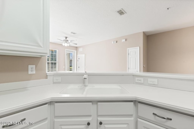 11251 Campfield Dr Unit 4107, Jacksonville, FL 32256 - kitchen with light countertops, white cabinetry, a sink, and ceiling fan