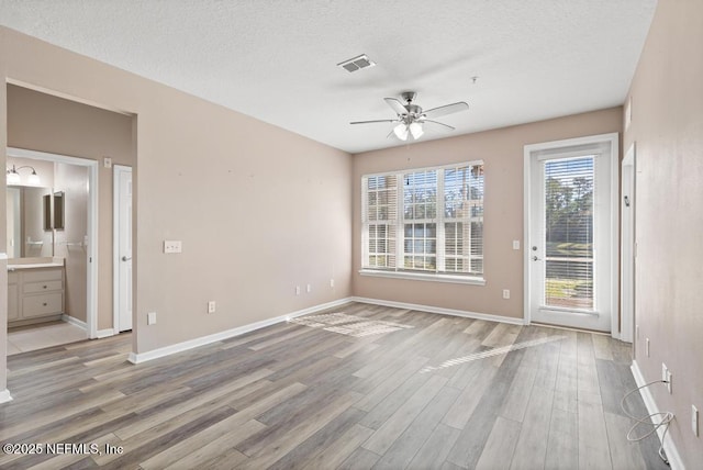 11251 Campfield Dr Unit 4107, Jacksonville, FL 32256 - empty room featuring light wood-style floors, a ceiling fan, baseboards, and a textured ceiling
