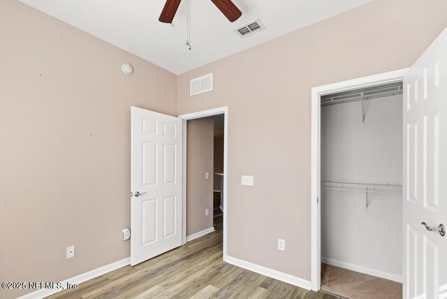 11251 Campfield Dr Unit 4107, Jacksonville, FL 32256 - unfurnished bedroom with a closet, baseboards, wood finished floors, and a ceiling fan