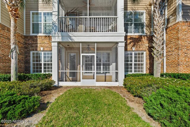 11251 Campfield Dr Unit 4107, Jacksonville, FL 32256 - back of house featuring brick siding, a sunroom, a balcony, and a yard