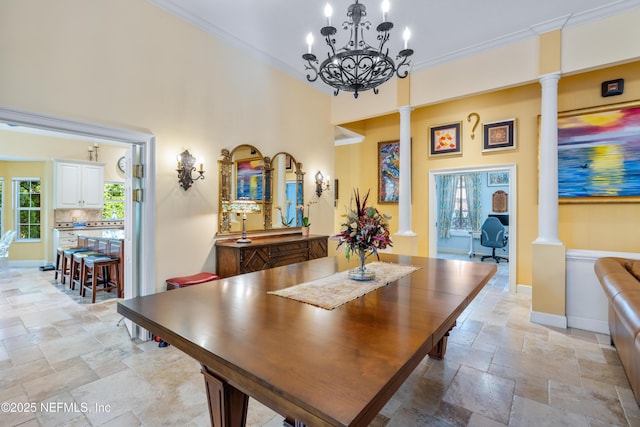 8 Rue Renoir, Palm Coast, FL 32137 - dining space featuring decorative columns, stone tile flooring, ornamental molding, a chandelier, and baseboards