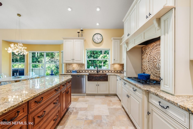8 Rue Renoir, Palm Coast, FL 32137 - kitchen with a sink, stainless steel appliances, backsplash, brown cabinetry, and healthy amount of natural light