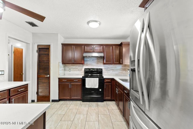 5342 Hickson Rd, Jacksonville, FL 32207 - kitchen featuring stainless steel fridge, electric range, under cabinet range hood, light countertops, and a textured ceiling