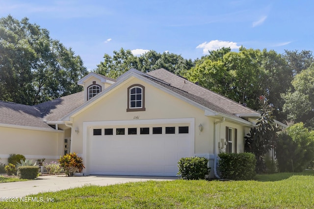 1141 Glengad, Ormond Beach, FL 32174 - view of front of property featuring stucco siding, an attached garage, driveway, roof with shingles, and a front lawn