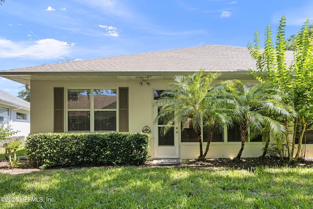 1141 Glengad, Ormond Beach, FL 32174 - rear view of property featuring stucco siding, a lawn, and roof with shingles