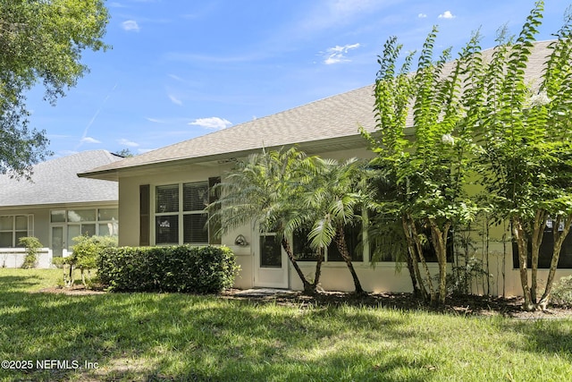 1141 Glengad, Ormond Beach, FL 32174 - rear view of house featuring a lawn, stucco siding, and roof with shingles