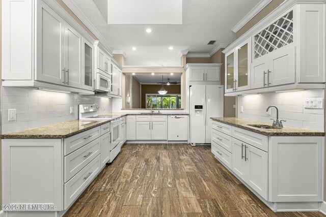 1141 Glengad, Ormond Beach, FL 32174 - kitchen with white appliances, crown molding, dark wood-style floors, glass insert cabinets, and white cabinets