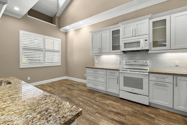 1141 Glengad, Ormond Beach, FL 32174 - kitchen with white appliances, backsplash, dark wood-type flooring, light stone countertops, and vaulted ceiling