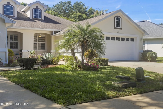 1141 Glengad, Ormond Beach, FL 32174 - view of front of home with roof with shingles, driveway, stucco siding, and a front lawn