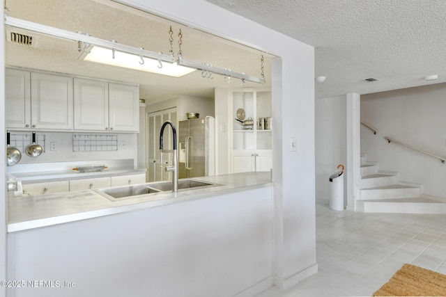 3115 Harbor Dr, Saint Augustine, FL 32084 - kitchen featuring stainless steel fridge with ice dispenser, a sink, light countertops, light tile patterned floors, and a textured ceiling
