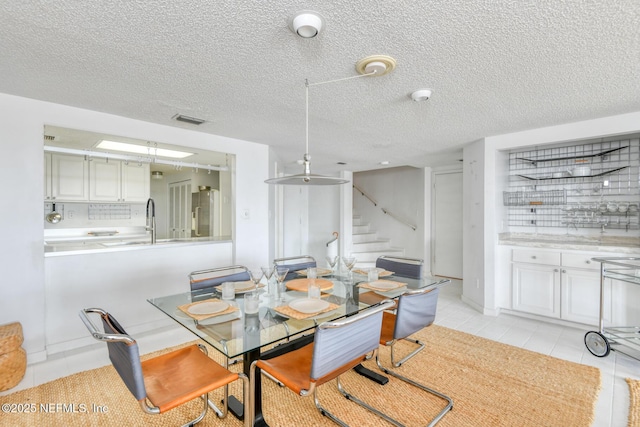 3115 Harbor Dr, Saint Augustine, FL 32084 - dining area with stairs, light tile patterned floors, and a textured ceiling