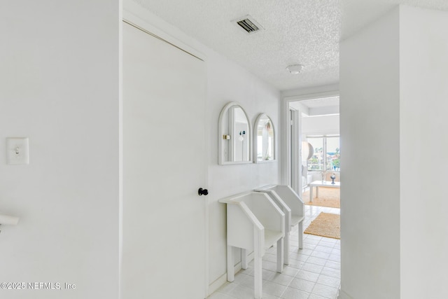3115 Harbor Dr, Saint Augustine, FL 32084 - hall with a textured ceiling, light tile patterned flooring, and baseboards