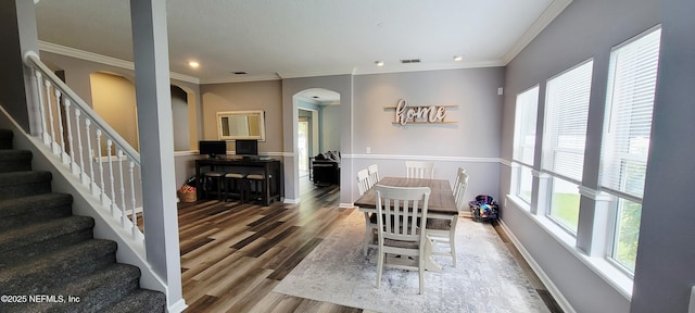 1691 Canopy Oaks Dr, Orange Park, FL 32065 - dining area featuring arched walkways, ornamental molding, wood finished floors, baseboards, and stairs