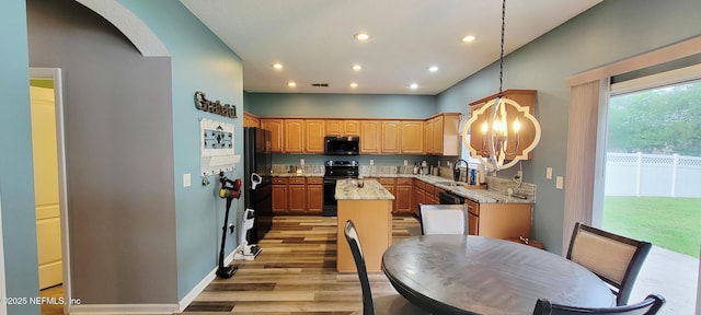 1691 Canopy Oaks Dr, Orange Park, FL 32065 - kitchen featuring black appliances, light wood-style flooring, a kitchen island, a sink, and recessed lighting