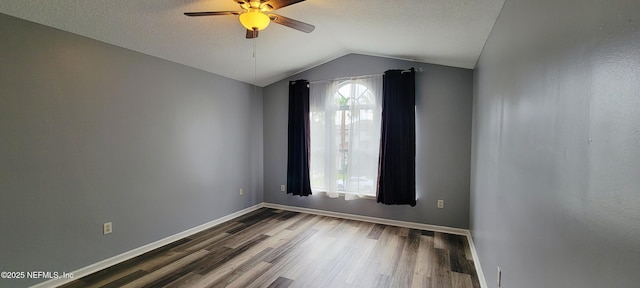 1691 Canopy Oaks Dr, Orange Park, FL 32065 - empty room with a ceiling fan, vaulted ceiling, wood finished floors, baseboards, and a textured ceiling
