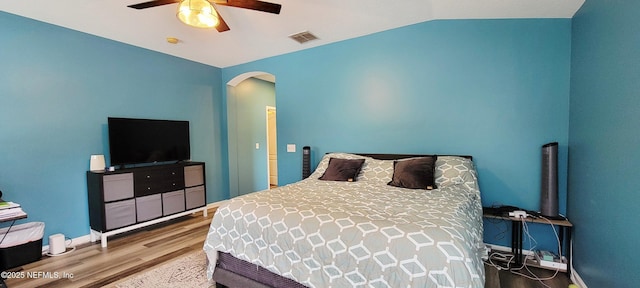 1691 Canopy Oaks Dr, Orange Park, FL 32065 - bedroom with wood finished floors, arched walkways, vaulted ceiling, a ceiling fan, and baseboards