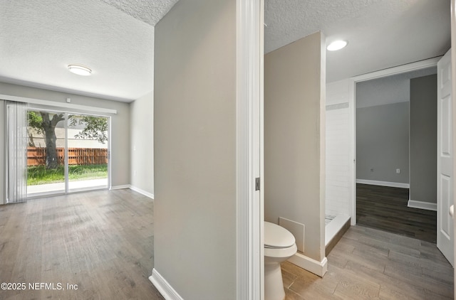 172 King Arthur Ct, Saint Augustine, FL 32086 - bathroom with a textured ceiling, toilet, wood finished floors, baseboards, and a shower
