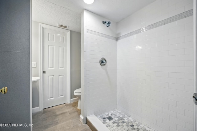 172 King Arthur Ct, Saint Augustine, FL 32086 - bathroom with wood finished floors, a stall shower, toilet, and a textured ceiling