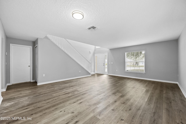 172 King Arthur Ct, Saint Augustine, FL 32086 - unfurnished living room with stairs, baseboards, wood finished floors, and a textured ceiling