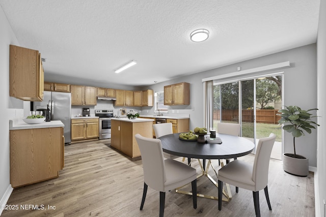 172 King Arthur Ct, Saint Augustine, FL 32086 - dining area featuring light wood-style floors, a textured ceiling, and baseboards