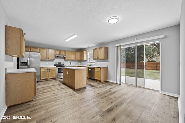 172 King Arthur Ct, Saint Augustine, FL 32086 - kitchen featuring appliances with stainless steel finishes, light countertops, a kitchen island with sink, light wood-style flooring, and baseboards