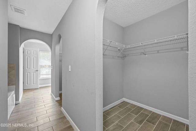 172 King Arthur Ct, Saint Augustine, FL 32086 - walk in closet with wood tiled floors and arched walkways