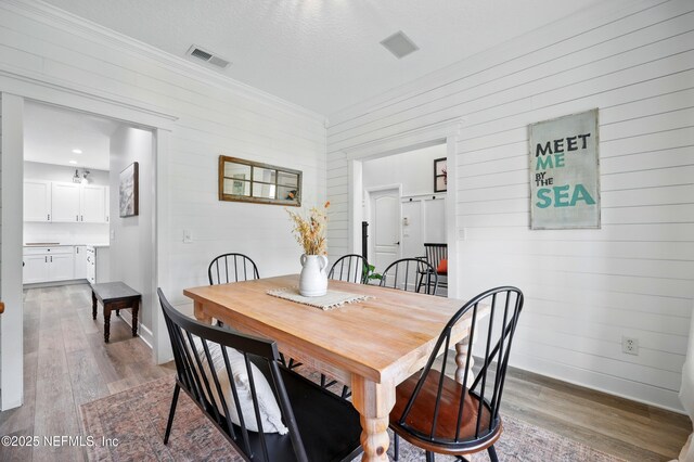 309 Elza Ln, Saint Augustine, FL 32086 - dining area featuring wood finished floors, wooden walls, baseboards, and crown molding