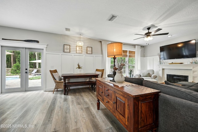 309 Elza Ln, Saint Augustine, FL 32086 - living area featuring a decorative wall, a brick fireplace, wood finished floors, french doors, and ceiling fan